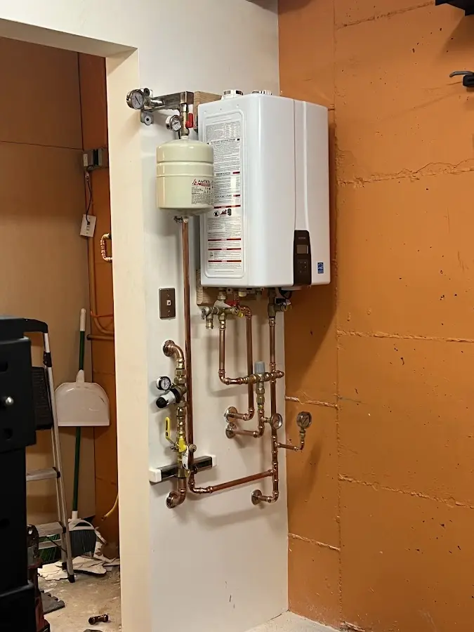 Plumbing technician inspecting water heater connections in Dakota Ridge